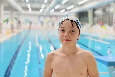 Yarı olimpik yüzme havuzunda yüzme eğitimi alan çocuk yüzücü