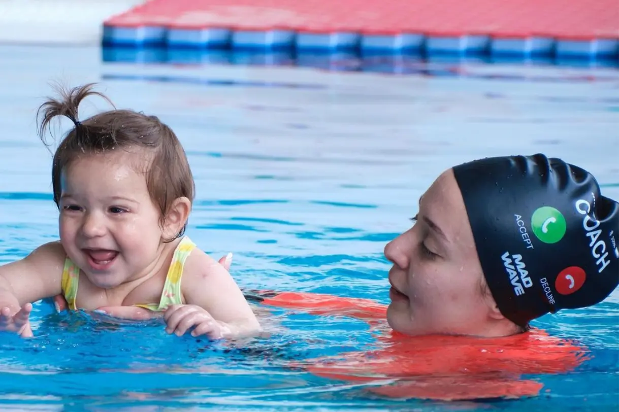 Bebek yüzme eğitimi alan bir öğrenci eğitim alıyor